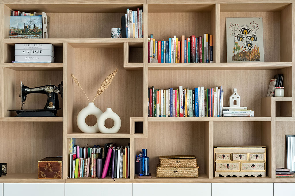 Detalle de la librería blanco y madera con estantes irregulares de madera