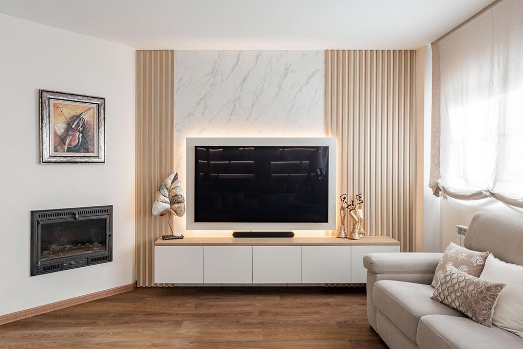 Vista del salón con mueble de tv a medida en blanco y madera con trasera palillería y mármol